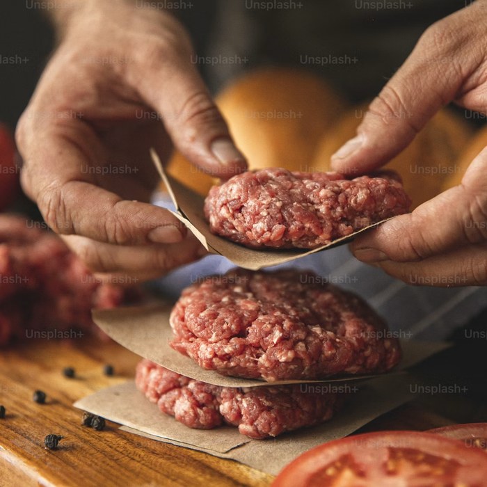 Detalhe da carne sendo preparada à mão